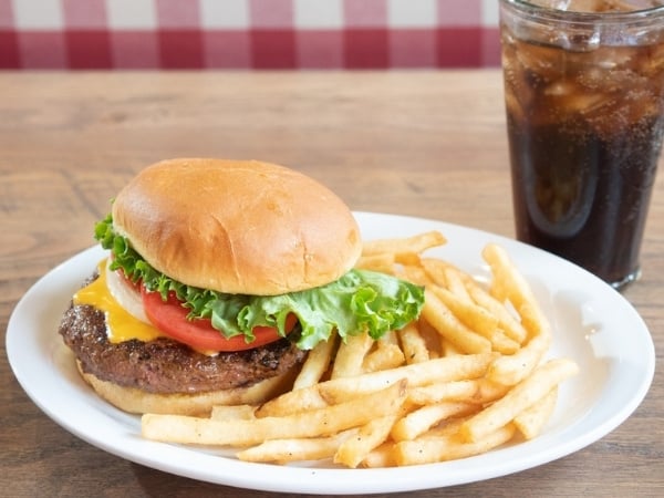 A lunch cheeseburger and soda.